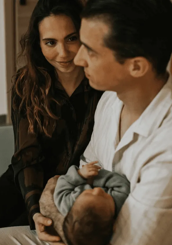 Couple de jeunes parents tenant tendrement leur nouveau-né