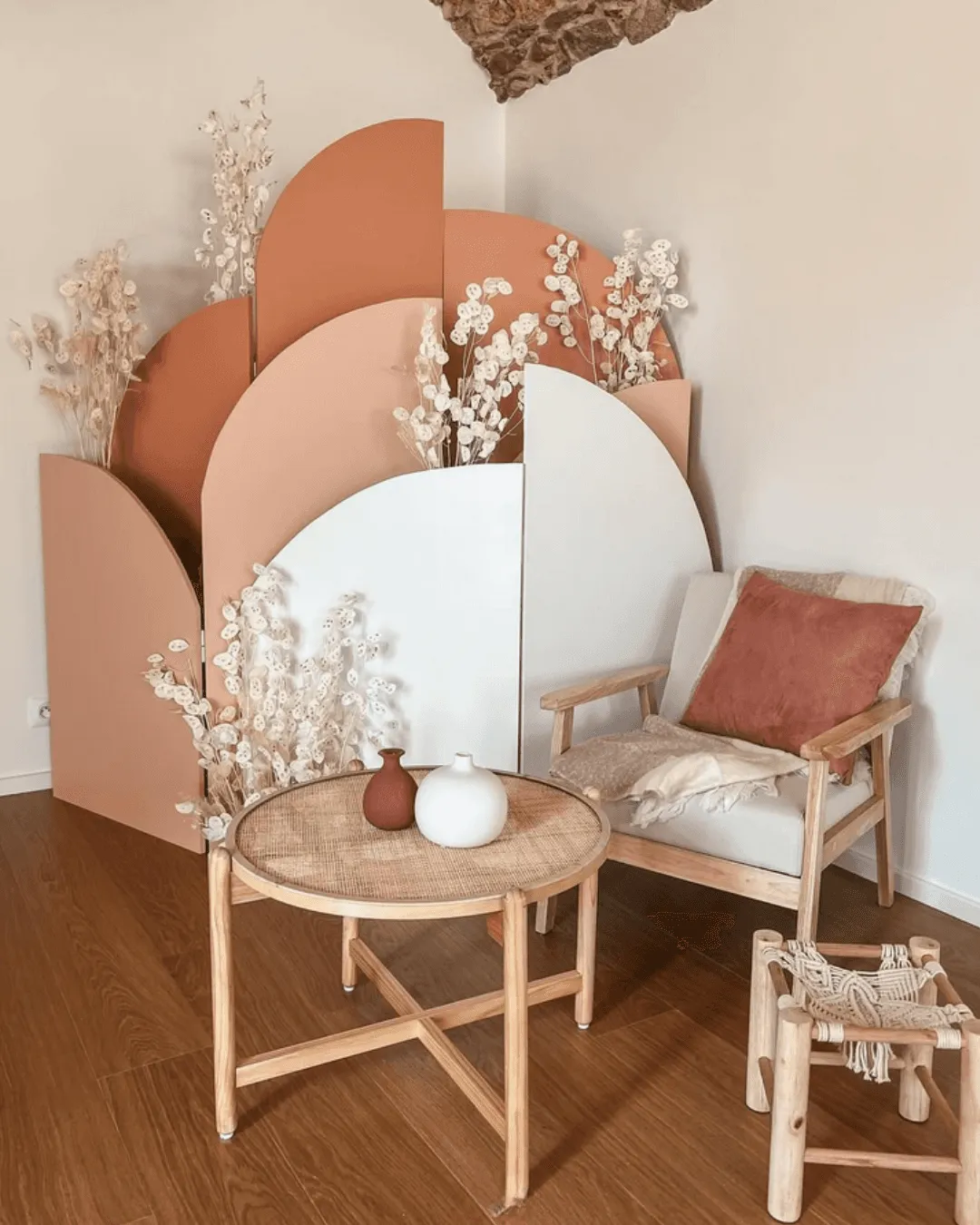 Coin détente de l'Institut Périnatal à Millery : fauteuil en bois, coussin rose et décor en arches
