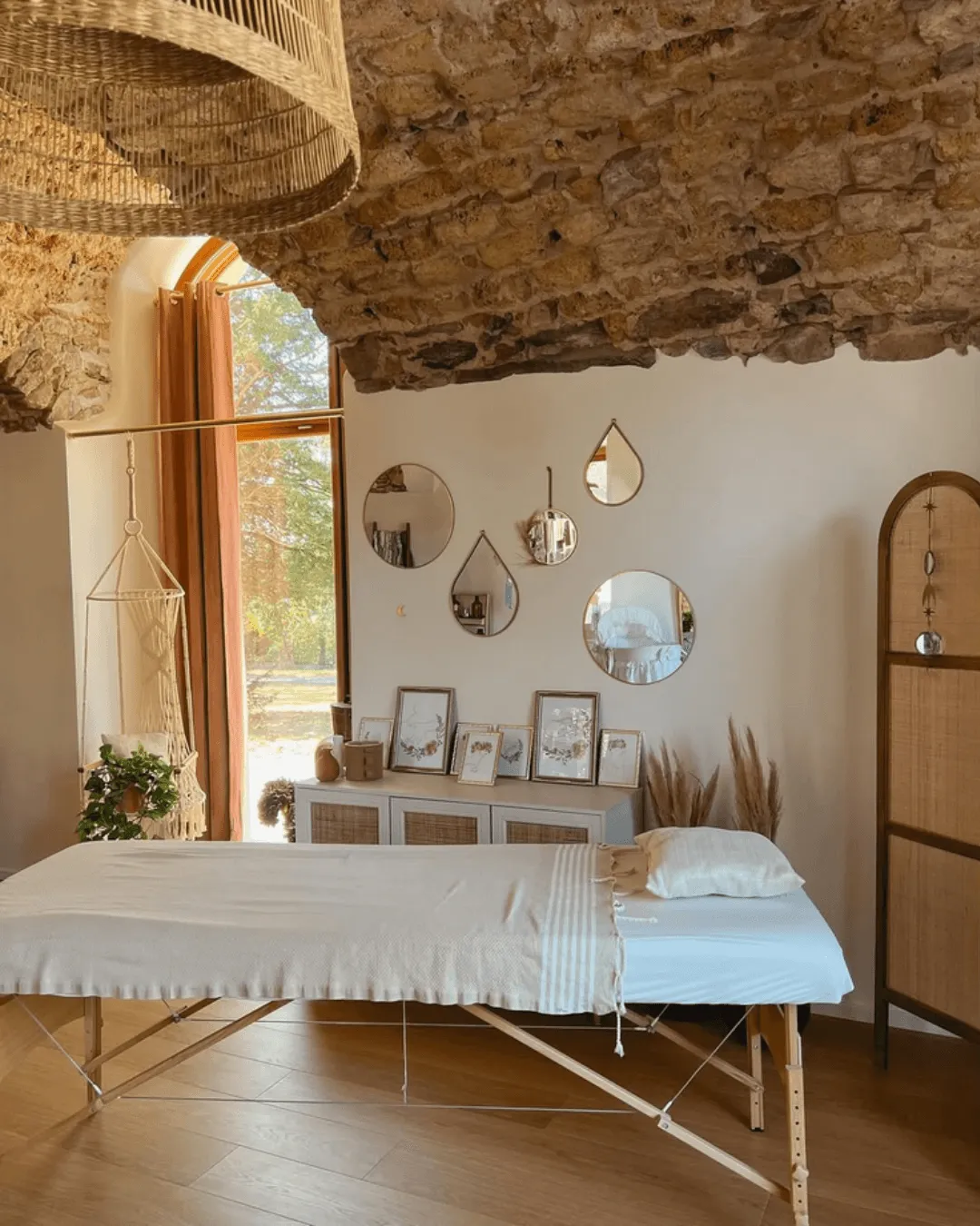 Salle de soin lumineuse de l'institut avec table de massage et miroirs