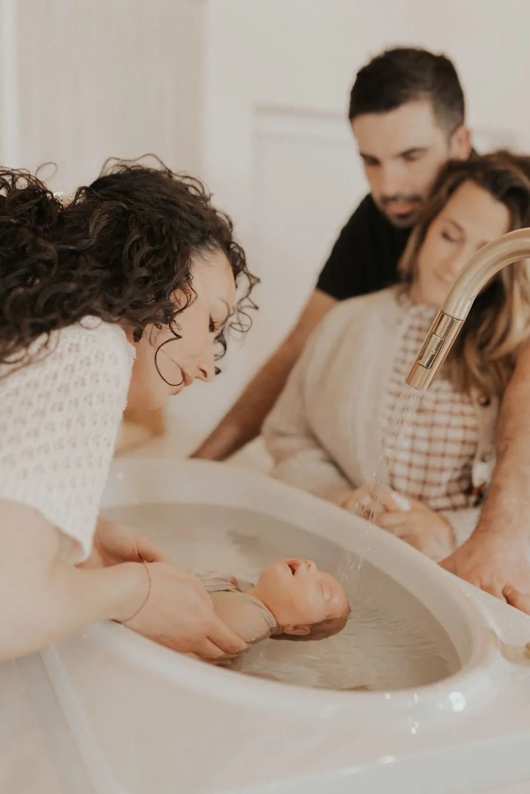 Laury Goncalves réalisant un bain d'accueil avec des parents