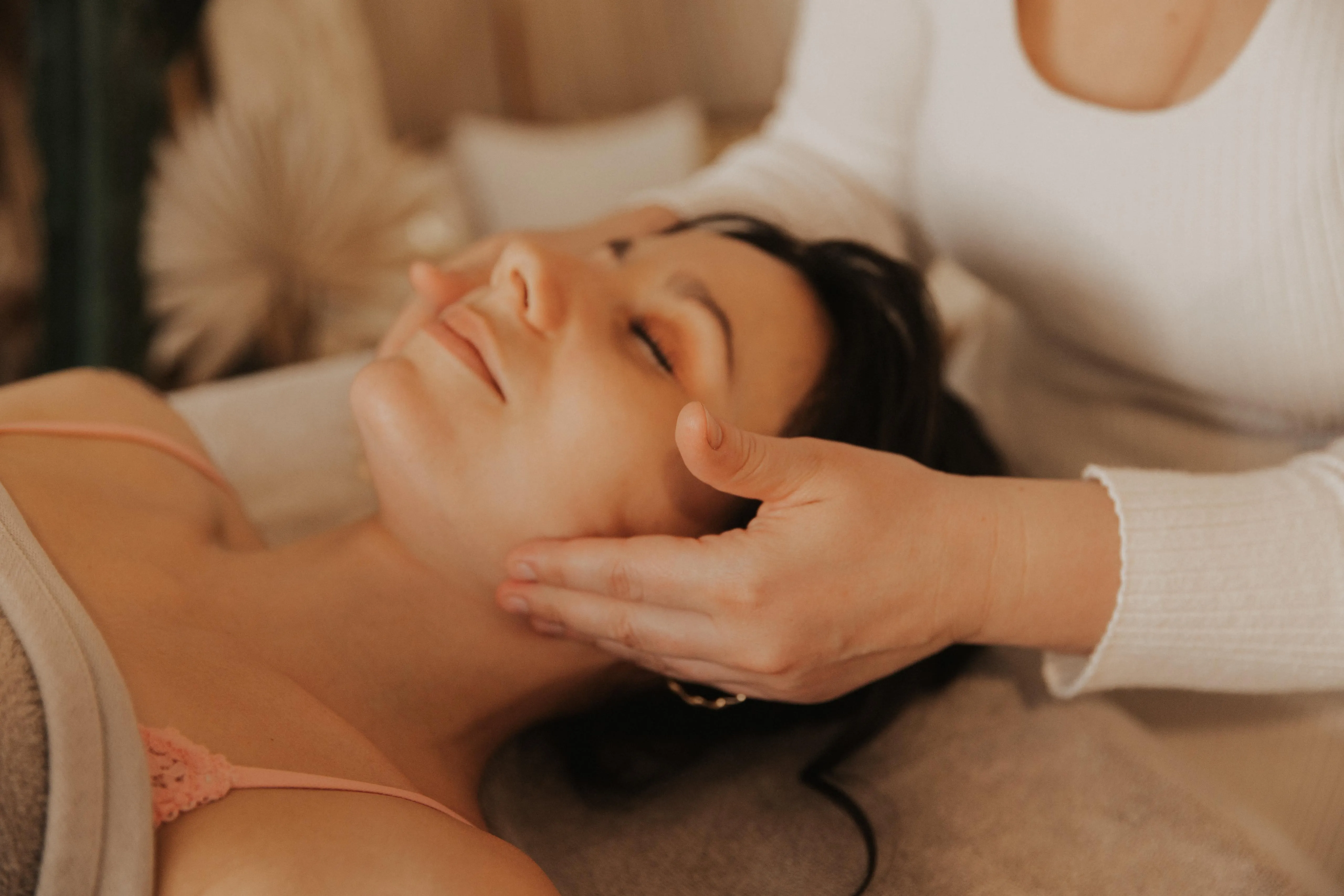 Femme détendue recevant le massage du visage Glow Maternité