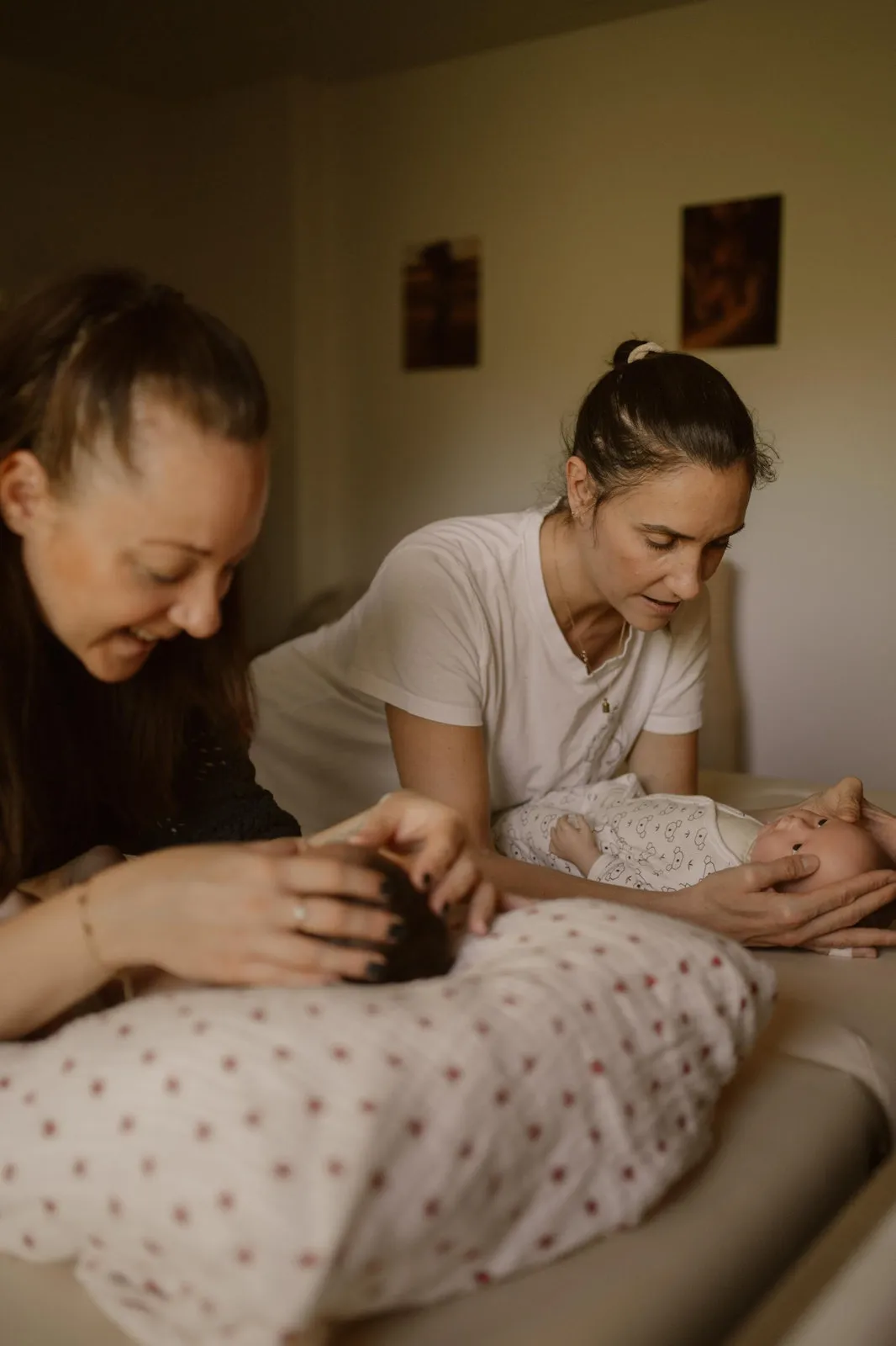 Deux professionnelles pratiquant le massage bébé sur poupon pendant un atelier